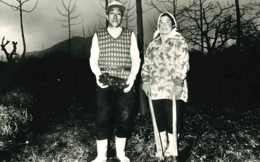 Filmstill aus THE MAGINO VILLAGE STORY: Ein Bauernpaar steht auf dem Feld.