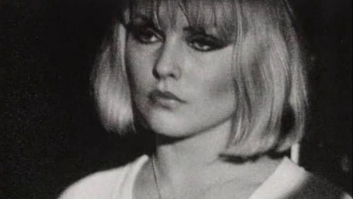 Film still from THE BLANK GENERATION: A woman with a short blonde bob, black eye make-up and a white shirt.