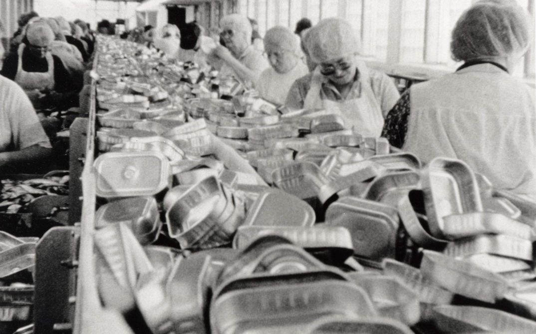 Film still from BELFAST, MAINE. Women work on the assembly line of a factory.