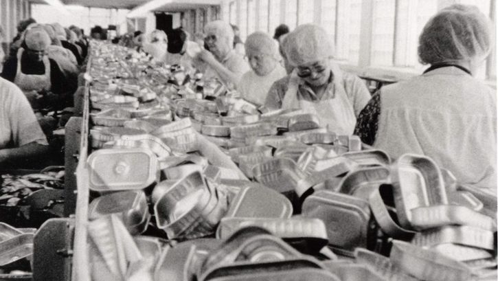 Film still from BELFAST, MAINE. Women work on the assembly line of a factory.
