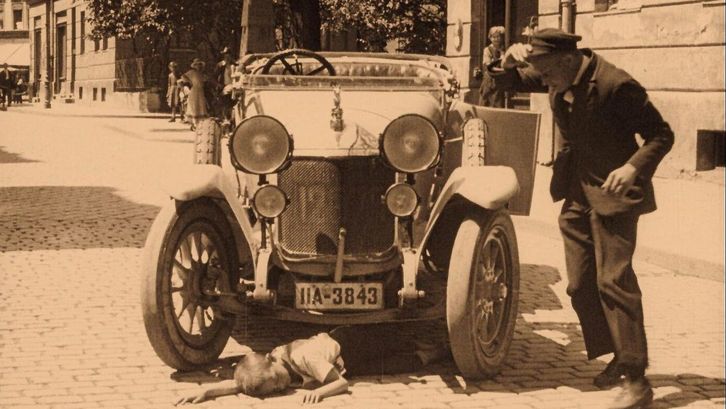 Film still from GEFAHREN DER GROSSSTADT-STRASSE: Crowds of people in a square over which a streetcar is running.
