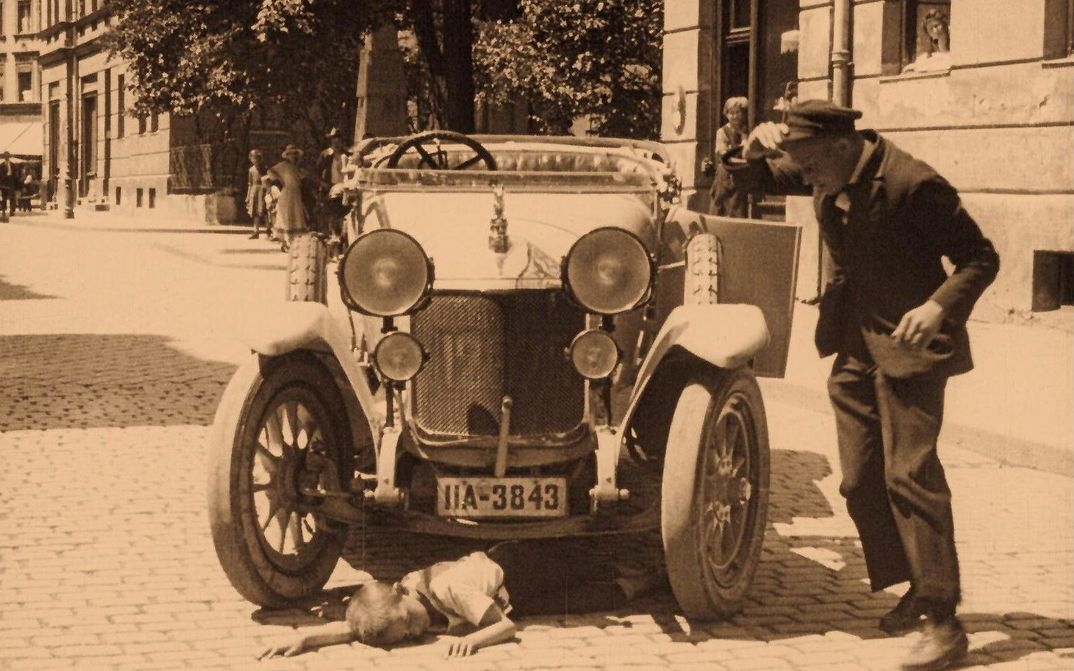 Film still from GEFAHREN DER GROSSSTADT-STRASSE: Crowds of people in a square over which a streetcar is running.