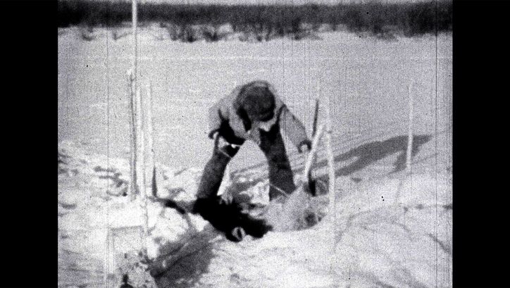 Film still from REVISITING KEEWATIN (BIOPHILIA EDIT): A blurred shot of a person in the snow.