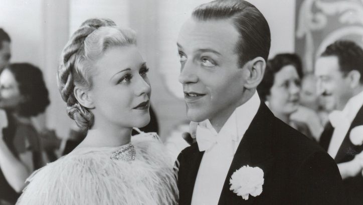 Filmstill aus TOP HAT. Ginger Rogers und Fred Astaire in festlicher Kleidung auf einem Ball.