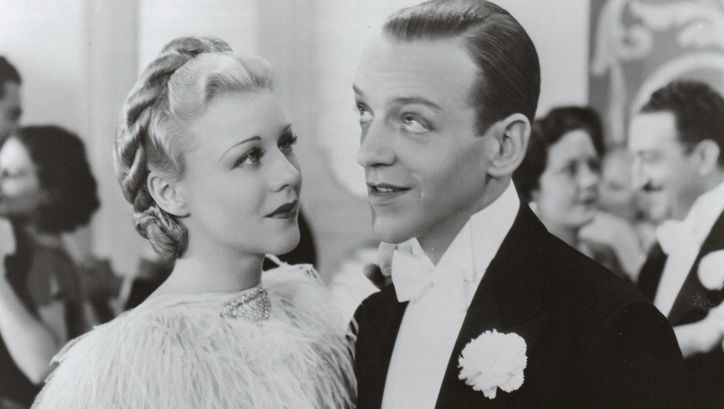 Filmstill aus TOP HAT. Ginger Rogers und Fred Astaire in festlicher Kleidung auf einem Ball.