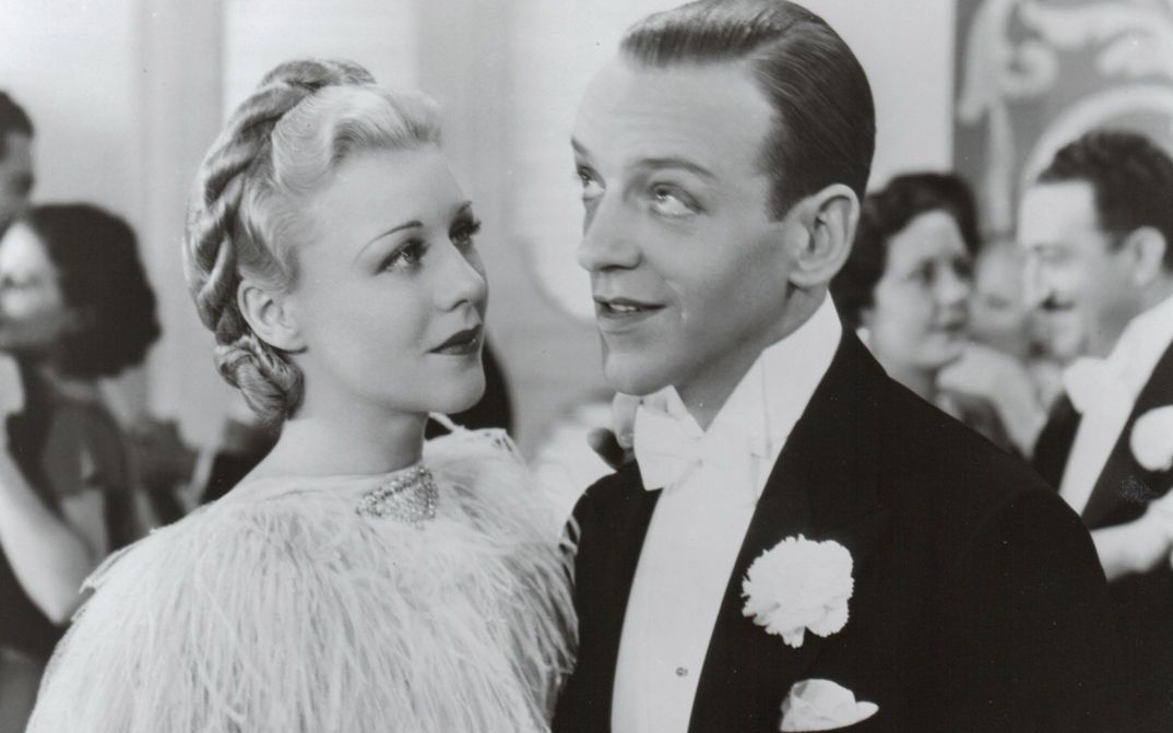Film still from TOP HAT. Ginger Rogers and Fred Astaire in festive attire at a ball.