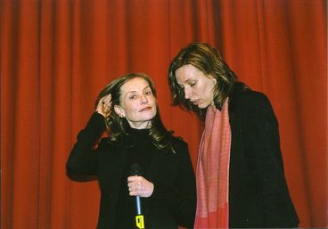 Isabelle Huppert im Kino mit Mikrofon, neben ihr die Übersetzerin Caroline Elias