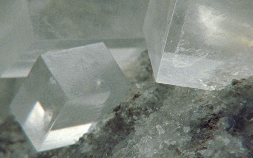 Filmstill aus dem Film „Last Things“ von Deborah Stratman. Drei große quaderförmige klare Kristalle in der oberen Bildhälfte auf einer Basis aus ähnlich klaren kleinen Kristallen in der unteren Bildhälfte.