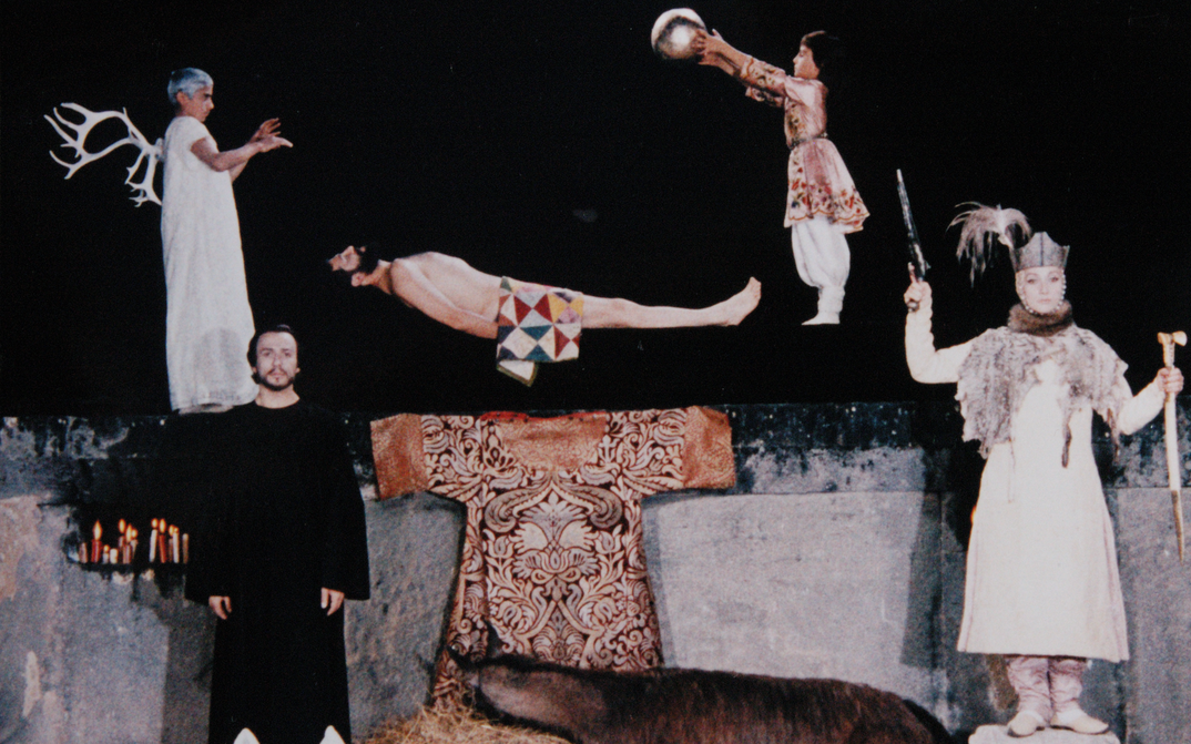 Film still from SAYAT NOVA: A surrealistic tableau with several figures against a dark background.