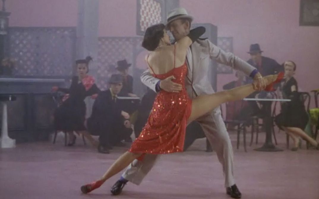 Film still from THE BAND WAGON: A spectacular dance scene with Cyd Charisse in a shiny red dress and Fred Astaire.