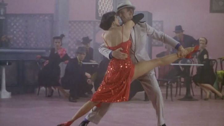 Film still from THE BAND WAGON: A spectacular dance scene with Cyd Charisse in a shiny red dress and Fred Astaire.