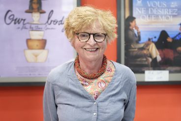 Porträt von Claire Simon vor Filmpostern