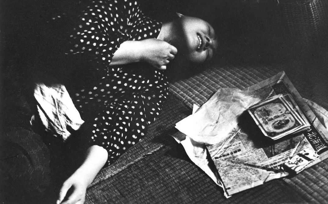 Film still from A FUGITIVE FROM THE PAST: A woman lies on a tatami covered floor with a desperate expression on her face.