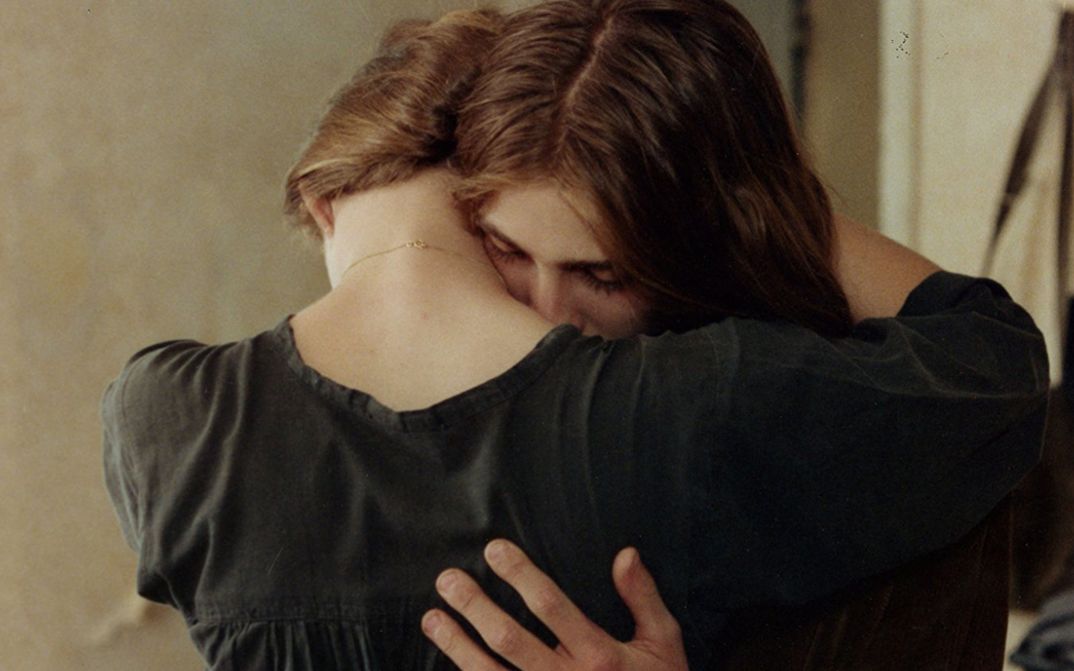 Filmstill aus LE DIABLE PROBABLEMENT. Ein Paar in einer Umarmung.