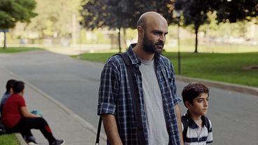 Filmstill from „Concrete Valley" by Antoine Bourges. A father and his son walking down a street