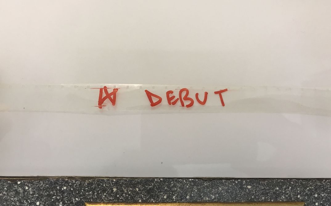 Auf einen transparenten Filmstreifen ist das Wort "Debut" mit rotem Filzstift geschrieben.