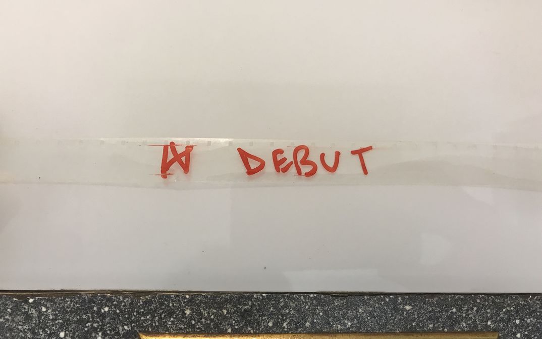 Auf einen transparenten Filmstreifen ist das Wort "Debut" mit rotem Filzstift geschrieben.