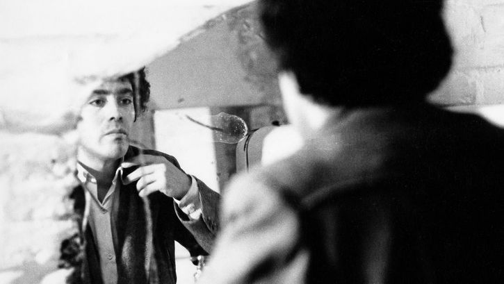 Photo from the shooting of "In der Wüste" by Rafael Fuster Pardo. A man looks at himself in the mirror and checks his clothing. 