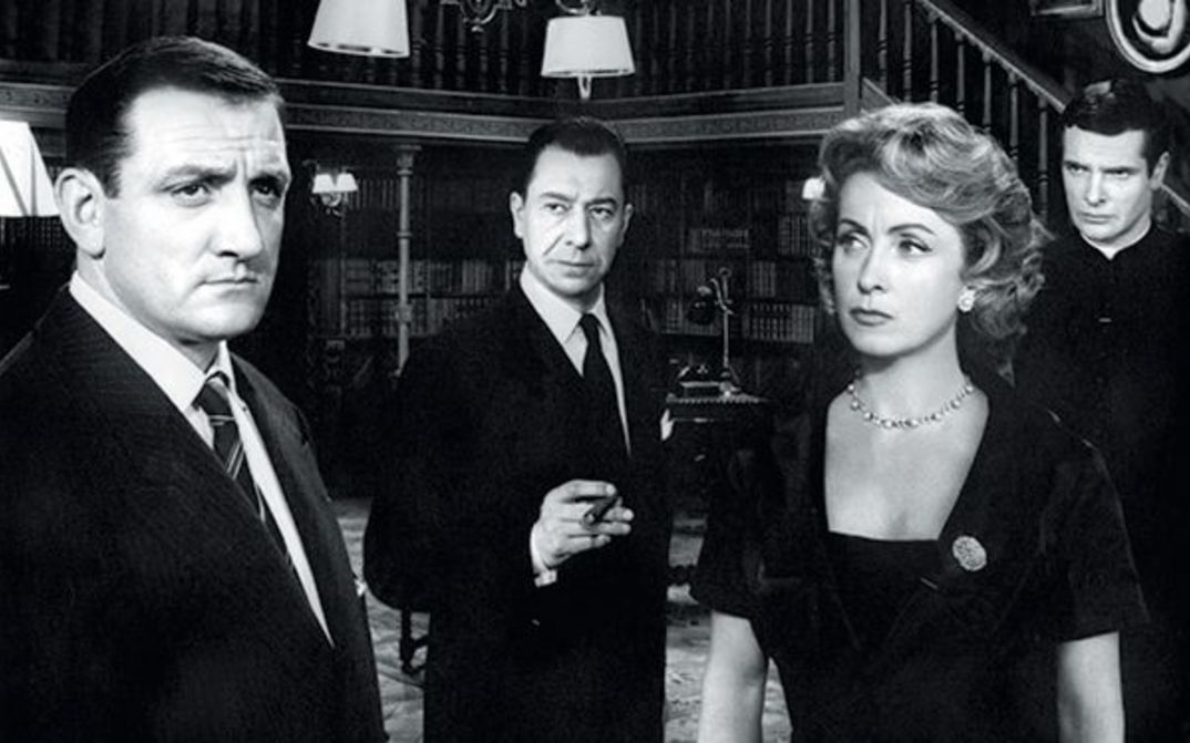 Film still from MARIE-OCTOBRE: Three men and a woman, all elegantly dressed, are standing in a room.