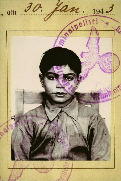 Film still from THE LIE by Melanie Spitta and Katrin Seybold. The picture shows an excerpt from a document. Above the photo of a Sinti boy is the stamp of the criminal investigation department with a swastika and the handwritten date January 30, 1943. 