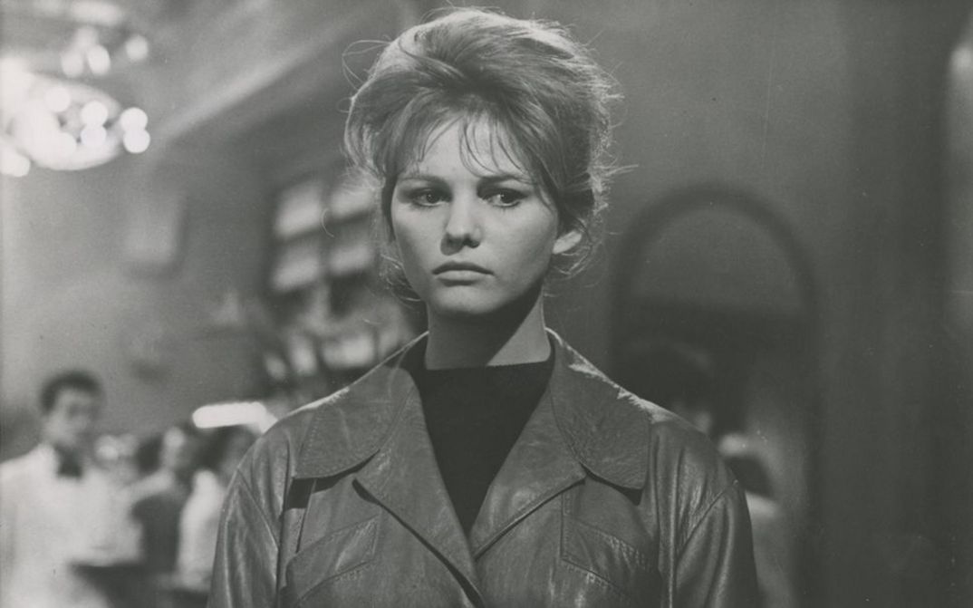 Film still from I DELFINI: Close-up of a young woman standing in a restaurant.