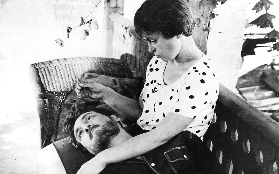 Filmstill auf BRIEF ENCOUNTERS: Eine Frau und ein Mann auf einer Sitzbank, er hat seinen Kopf in ihrem Schoß, sie streichelt seine Haare.