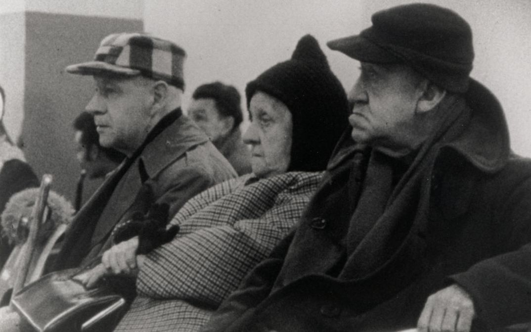 Filmstill aus WELFARE. Drei ältere Menschen sitzen in einem Wartezimmer.