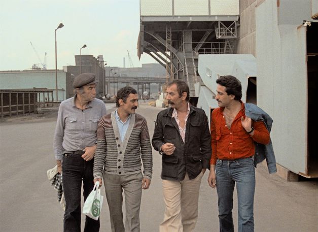 Still from the film „Kara Kafa“ by Korhan Yurtsever. Four men walking on an industrial site.