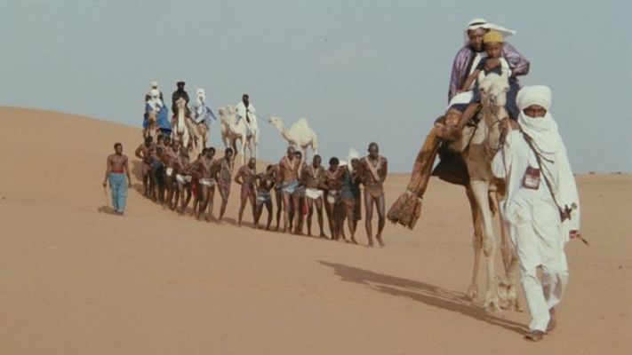 Film still from SHAIHU UMAR: A caravan in the desert. In the middle are people who have been captured.
