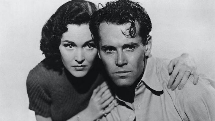 Film still from LET US LIVE: A woman holds a man by the shoulders, both look into the distance in fright.
