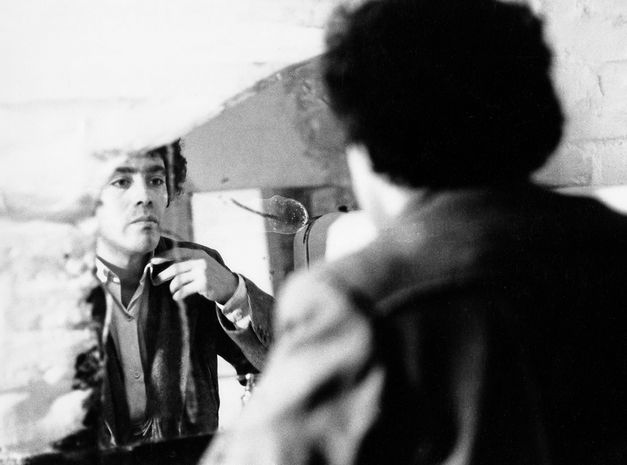 Photo from the shooting of "In der Wüste" by Rafael Fuster Pardo. A man looks at himself in the mirror and checks his clothing. 