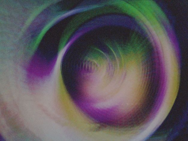 Still from the film "vs" by Lydia Nsiah. Abstract spiral in green, blue and purple.