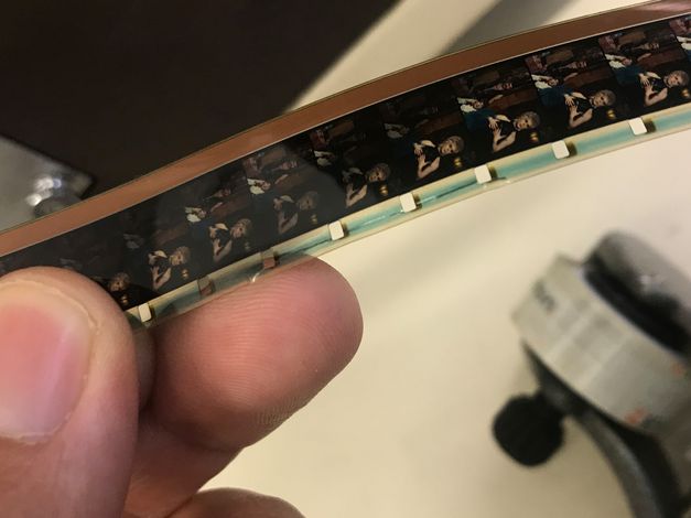 Eine Hand hält einen 16-mm-Filmstreifen.
