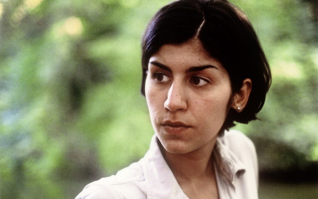 Still from the film "A fine day" by Thomas Arslan. Close up of a young woman in front of greenery.