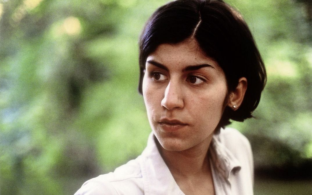 Still from the film "A fine day" by Thomas Arslan. Close up of a young woman in front of greenery. 