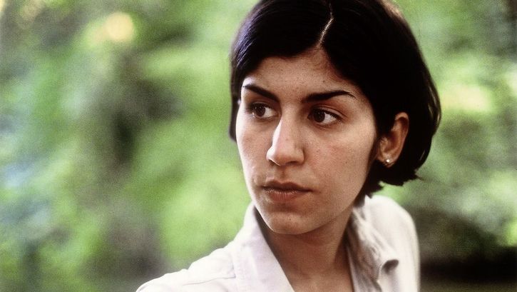 Still from the film "A fine day" by Thomas Arslan. Close up of a young woman in front of greenery. 