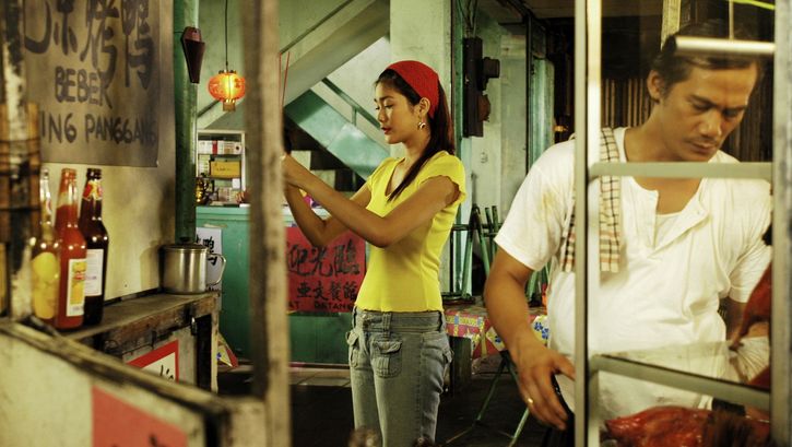 Film still from BERBAGI SUAMI: Two restaurant employees are standing in the kitchen.