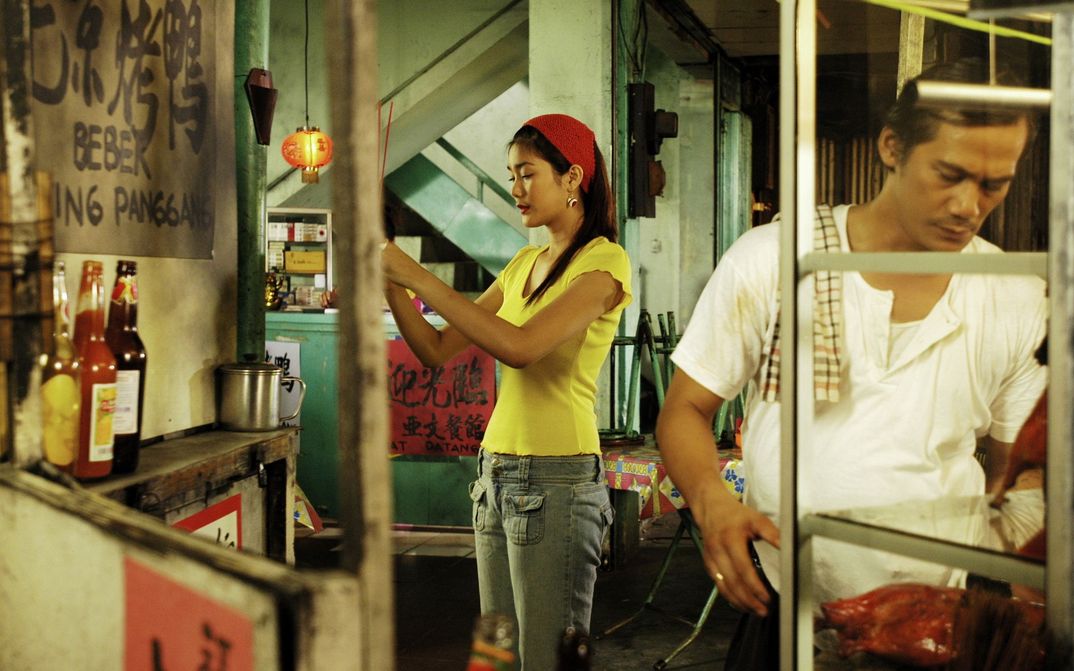 Filmstill aus BERBAGI SUAMI: Zwei Angestellte eines Restaurants stehen in der Küche.