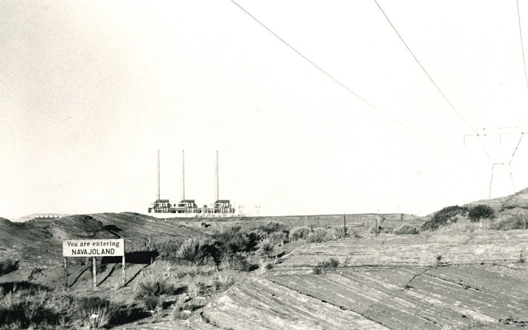 Filmstill aus SACRIFICE AREA: Ansicht einer kahlen Landschaft, auf einem Schild steht: " You are entering Navajoland"