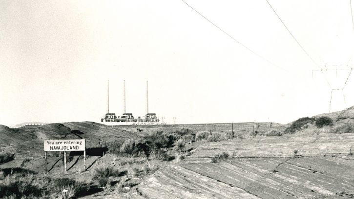 Film still from SACRIFICE AREA: View of a barren landscape, a sign says: " You are entering Navajoland".