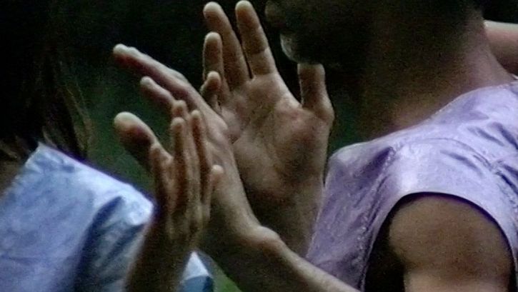 Filmstill aus „Afterwater“ von Dane Komljen. Eine Nahaufnahme der Arme und Oberkörper von zwei Personen. 