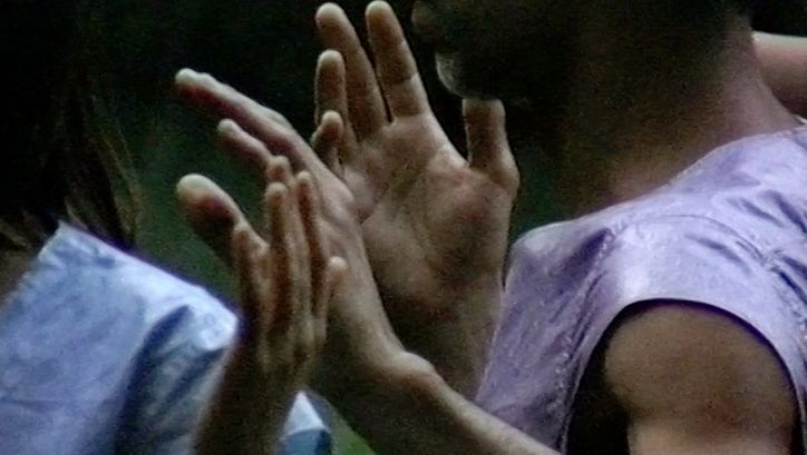 Filmstill aus „Afterwater“ von Dane Komljen. Eine Nahaufnahme der Arme und Oberkörper von zwei Personen. 