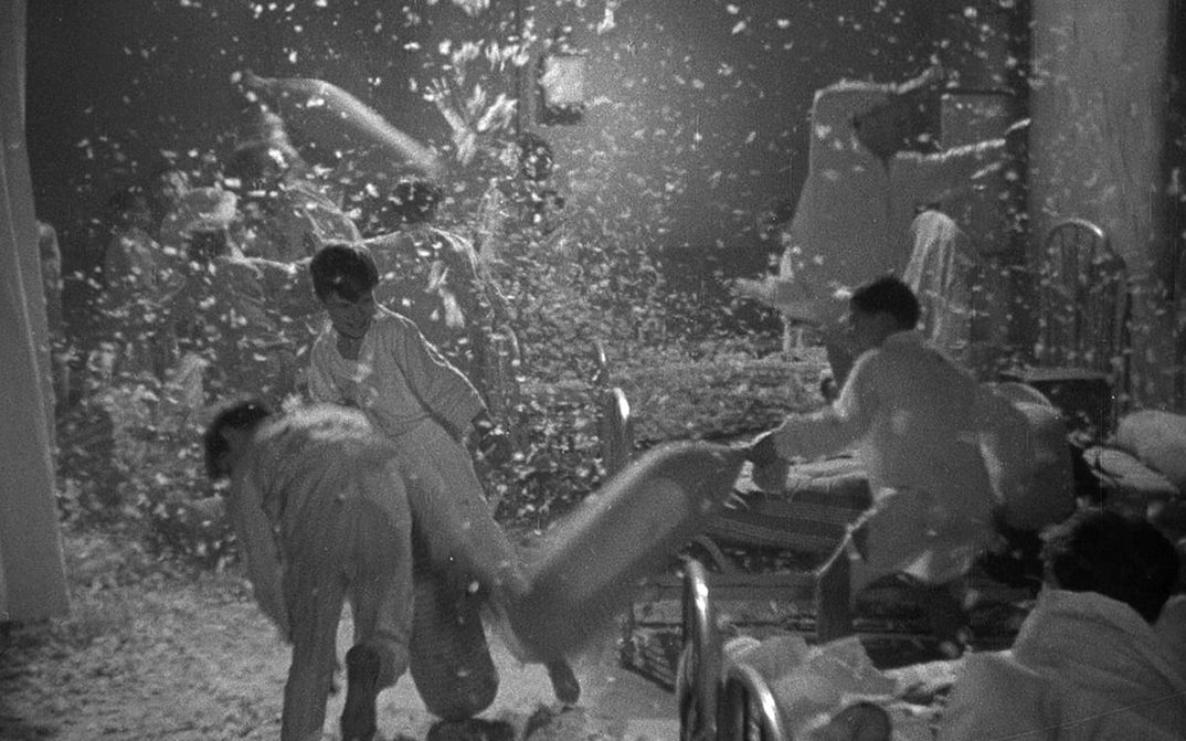 Film still from ZÉRO DE CONDUITE: A pillow fight between children in a dormitory. Feathers are flying everywhere.