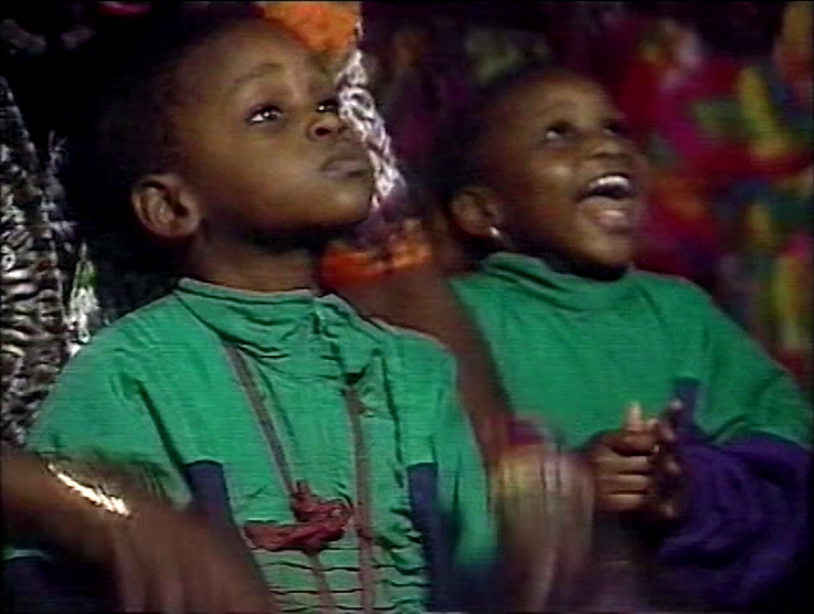 Still from the film "Moune Ô" by Maxime Jean-Baptiste. Close up of two toddlers in green clothes