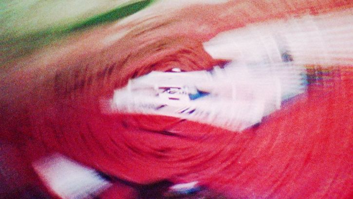 Still from the film "vs" by Lydia Nsiah. Abstract spiral in red and green. A house-like structure can also be seen.