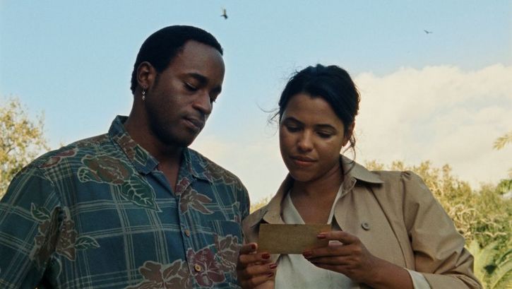 Filmstill aus THE BALLAD OF SUZANNE CÉSAIRE: Ein Mann und eine Frau betrachten einen Zettel, den die Frau in der Hand hält.