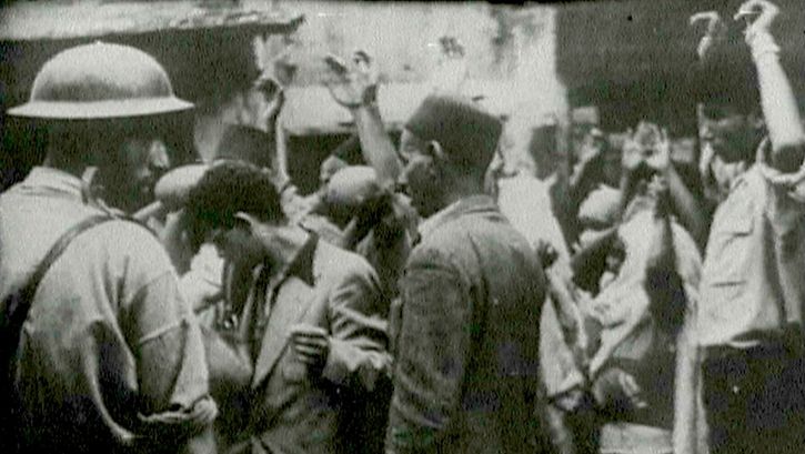 Filmstill aus dem unvollendeten Film "Insurrectionelle": Eine Straßenszene, mehrere Menschen halten ihre Hände hoch.