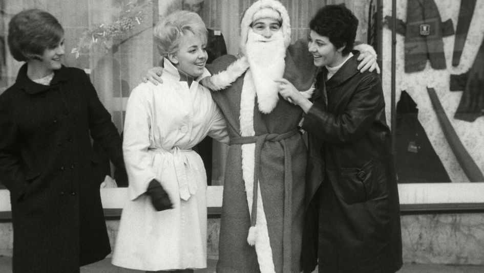 Filmstill aus LE PÈRE NOEL A LES YEUX BLEUS: Drei Frauen stehen vor einem Schaufenster neben einem Weihnachtsmann und scherzen mit ihm.