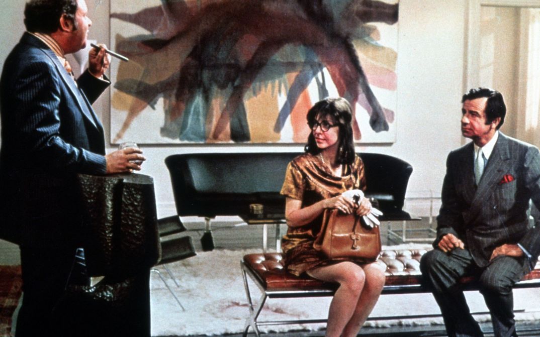 Film still from A NEW LEAF: A woman and two men are sitting in a smart office.