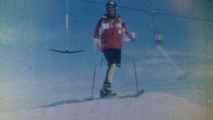 Filmstill aus SCHUSS!: Aufnahme eines Skifahrers vor einem Bügellift. Das Bild ist grobkörnig.